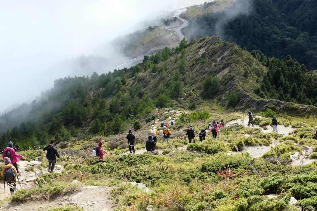 A group of hikers descends a foggy mountain trail in scenic Nantou County, Taiwan.